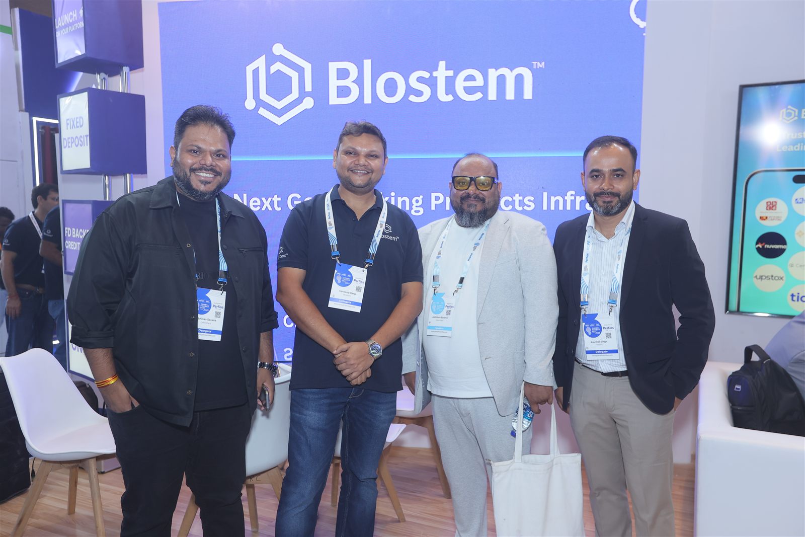 Partners visiting the Blostem booth under the Blostem logo wall